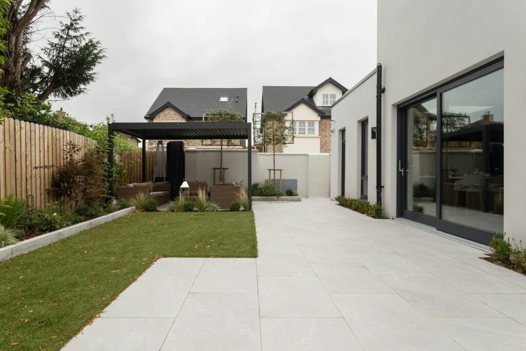 Pergola lames orientables autoportée dans un jardin paysagé